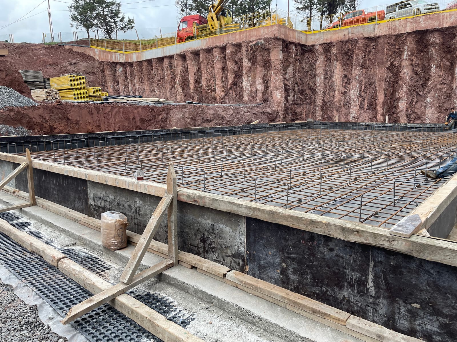 A grid of steel reinforcement laid across a concrete foundation slab.